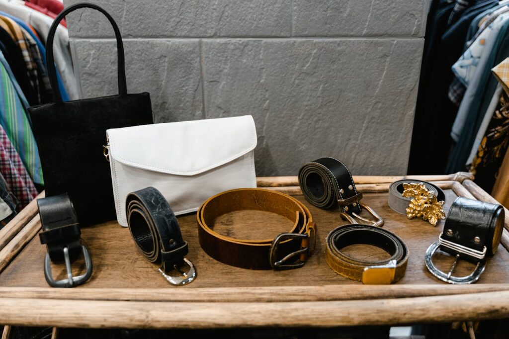 A collection of stylish belts and handbags displayed on a wooden rack in a fashion boutique.